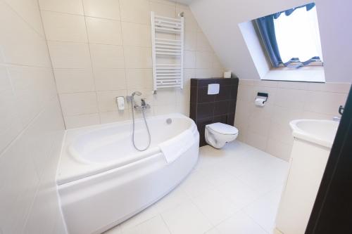 Un baño con bañera blanca y un inodoro. en Villa Elizabeth, en Bolków