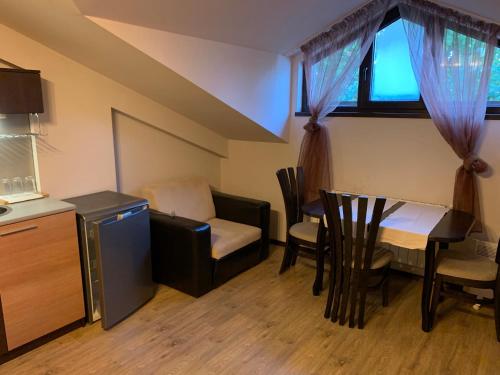 a small room with a kitchen and a table and chairs at 7 apartments in Alexander complex in Bansko