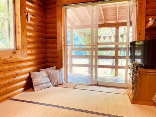 a living room with a large window in a log cabin at Mori no Kuni - Vacation STAY 03967v in Ōma