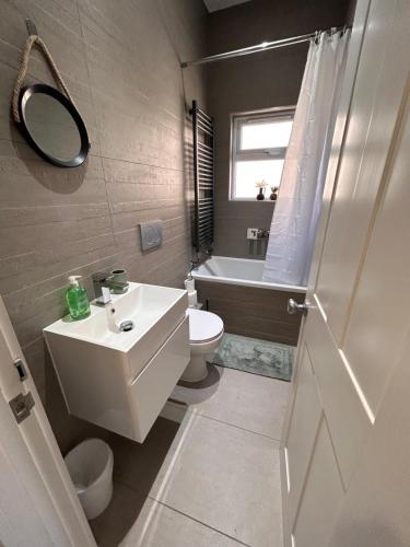 La salle de bains est pourvue d'un lavabo, de toilettes et d'une baignoire. dans l'établissement Brighton City Flat Perfect for long stays, à Brighton et Hove