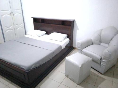 1 dormitorio con 1 cama, 1 sofá y 1 silla en Appart meublé le Dakota, en Yaoundé
