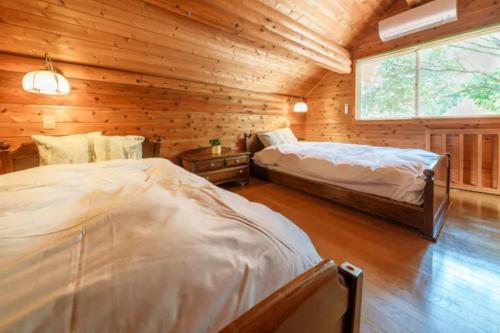a bedroom with two beds in a log cabin at Mori no Kuni - Vacation STAY 03957v in Ōma