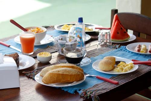 a table with plates of food and drinks on it at Pousada Semente in Arraial d'Ajuda