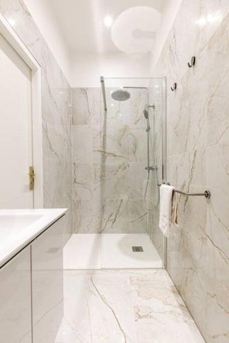 une salle de bain blanche avec une douche et un lavabo dans l'établissement Très chic studio/Petite France, à Strasbourg