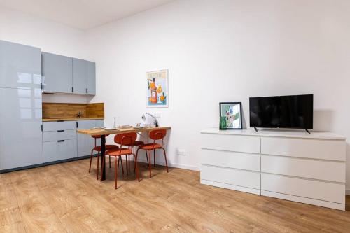 une cuisine avec une table et des chaises et une télévision dans l'établissement Très chic studio/Petite France, à Strasbourg