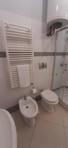 a white bathroom with a toilet and a bidet at Vila Kinostudio (Togu 2) in Tirana