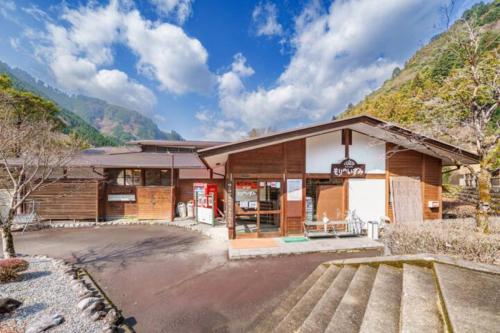 a building with a gas station with mountains in the background at Mori no Kuni - Vacation STAY 03790v in Ōma