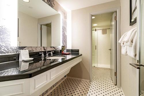 a bathroom with a sink and a large mirror at Williamsburg Lodge, Autograph Collection in Williamsburg