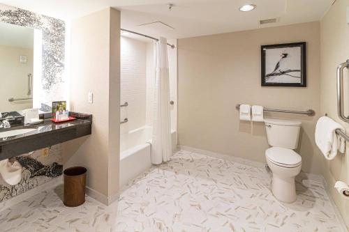 a bathroom with a toilet and a sink and a tub at Williamsburg Lodge, Autograph Collection in Williamsburg