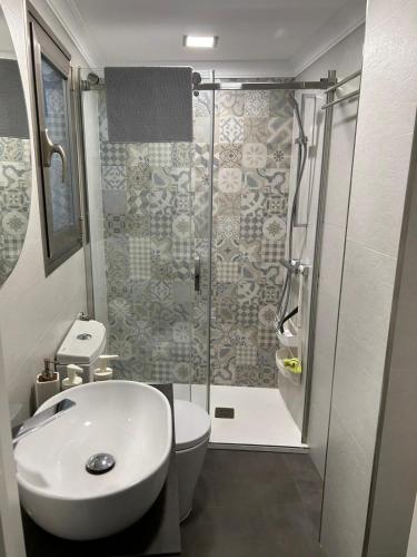 a bathroom with a shower and a toilet and a sink at Casa Rosa1 in Valle de Abdalagís