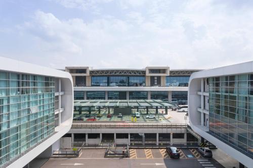 une vue aérienne sur un bâtiment avec un parking dans l'établissement Sheraton Milan Malpensa Airport Hotel & Conference Centre, à Ferno