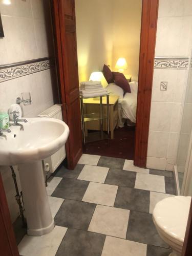 a bathroom with a sink and a bedroom with a bed at Executive Serviced apartments 2 in Forfar