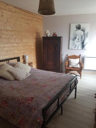 1 dormitorio con 1 cama y 1 silla en Maison de bourg, comme a la maison ! en Cheviré-le-Rouge