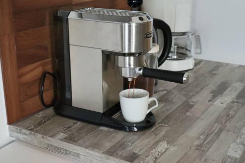 a coffee maker is making a cup of coffee at Haus Wiese & Lagune in Ettenheim