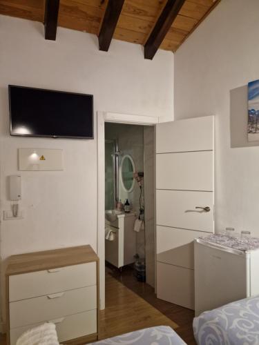 Dieses weiße Zimmer verfügt über einen TV an der Wand. in der Unterkunft Habitaciones boutiques in Algeciras