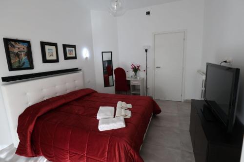 a bedroom with a red bed with towels on it at B&B Royal Palace of Napoli & Reggia di Caserta in Caserta