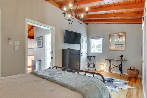 a bedroom with a bed and a television and a table at Le-Petit Chalet with Fire Pit about 15 Mi to Asheville in Black Mountain