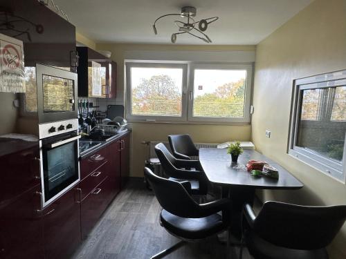 a kitchen with a dining room table and chairs at Modernes Apartment 3 mit 5 Schlafzimmer 8 einzelne Betten in Dortmund