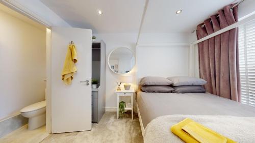een witte slaapkamer met een bed en een toilet bij Modern Cardiff City Apartment in Cardiff