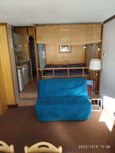 un salon avec un canapé bleu et une cuisine dans l'établissement Tandem de choc - Neige et Soleil, à Isola 2000