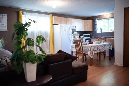 a kitchen and dining room with a table and a white refrigerator at Logis du Bonheur in Rouyn-Noranda