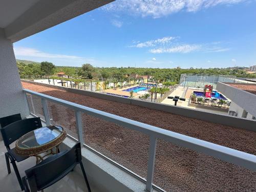 a balcony with chairs and a view of a pool at Recanto do Bosque Apartamentos para Temporada in Caldas Novas