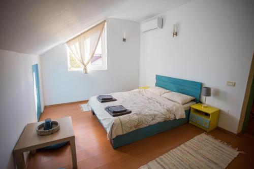Un dormitorio con una cama y una mesa y una ventana. en Domus Ex Animo, en Bucarest