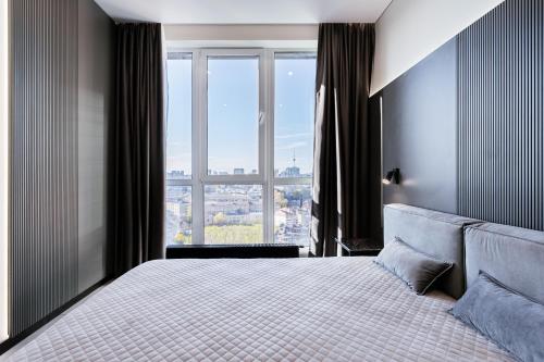 een slaapkamer met een groot bed en een groot raam bij Great View Apartment in historical city center in Kiev