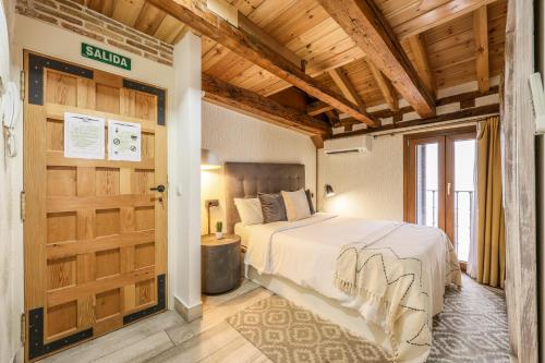 - une chambre avec un lit et un plafond en bois dans l'établissement AP Plaza de España 12, à Madrid