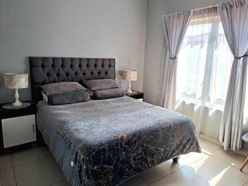 a bedroom with a bed and a large window at Cozy Sparrow Hideaway in Sandton