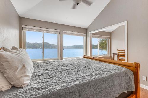 Dormitorio con cama y vistas al agua en Summit Lake Getaway, en Kamilche