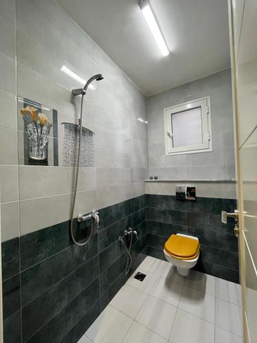 bagno con doccia e servizi igienici con sedile giallo di Sublime duplex au Bardo Tunis a Le Bardo