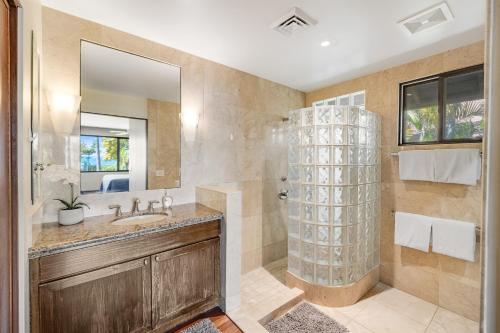 ein Bad mit einer Dusche, einem Waschbecken und einem Spiegel in der Unterkunft South Shore Paradise - 30-Night Minimum in Honolulu