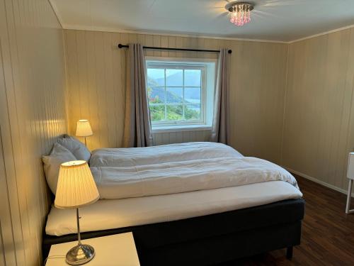 1 dormitorio con 1 cama con ventana y lámpara en Aurlandsfjord Panorama en Aurland