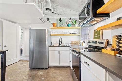 a kitchen with white cabinets and a stainless steel refrigerator at The Ahtanum Cottage - NEW hot tub and great views! in Yakima