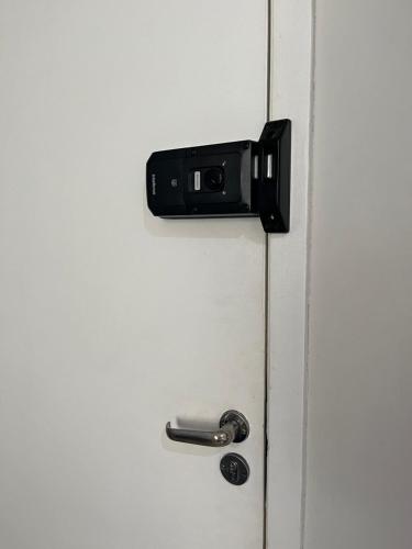 a door with a cell phone sticking out of it at Apartamento na Zonal Sul 2 Vagas Carro in Uberlândia