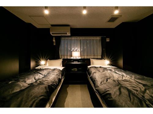 a bedroom with two beds and a window at VILLA KOSHIDO ODORI - Vacation STAY 04745v in Sapporo