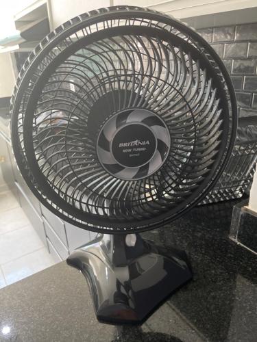 a fan on a stand on top of a counter at Apartamento na Zonal Sul 2 Vagas Carro in Uberlândia