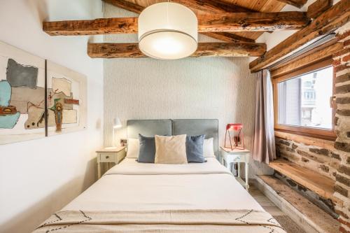 een slaapkamer met een bed en een bakstenen muur bij Apartamento Plaza de España 2 in Madrid