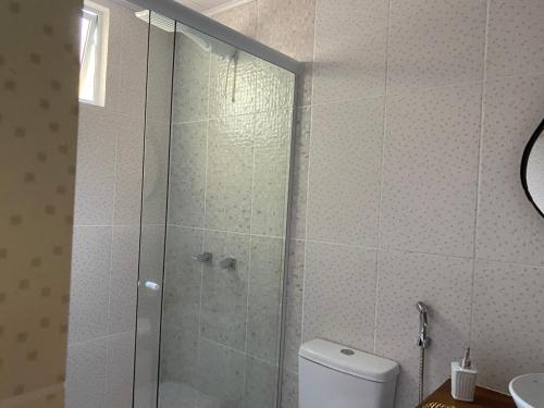 a bathroom with a shower with a toilet and a sink at Pousada Casa da Montanha in Angra dos Reis