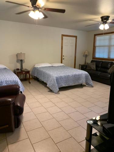 a bedroom with a bed and a couch and a ceiling fan at Holly Park Marina in Milam