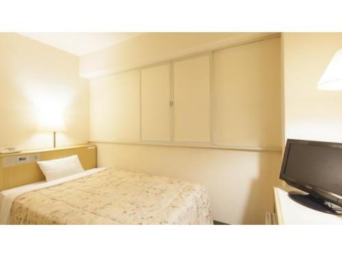 a small bedroom with a bed and a television at Green Hotel Kitakami - Vacation STAY 09805v in Kitakami