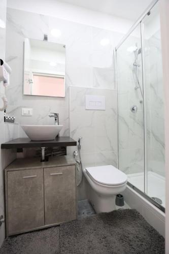 a bathroom with a sink and a toilet and a shower at B&B Royal Palace of Napoli & Reggia di Caserta in Caserta