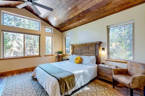 een slaapkamer met een bed, een stoel en ramen bij The Clicky-Clicky Cabin in Tahoma