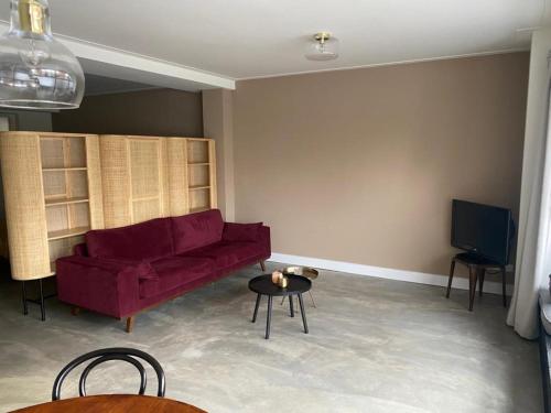 sala de estar con sofá rojo y mesa en Stijlvol ruim studio-appartement nabij historisch centrum, en Amersfoort