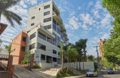 a white apartment building with a car parked in front of it at Macondo in Asunción