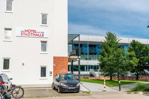 a car parked in a parking lot in front of a building at Das Hotel an der Stadthalle - Rostock Hbf in Rostock