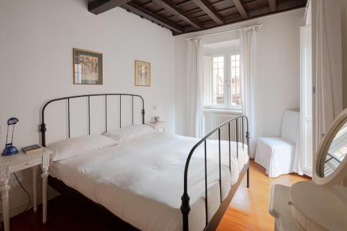 a bedroom with a white bed with a metal frame at Elegante rifugio in centro storico Roma tra Piazza del Popolo e Piazza di Spagna in Rome