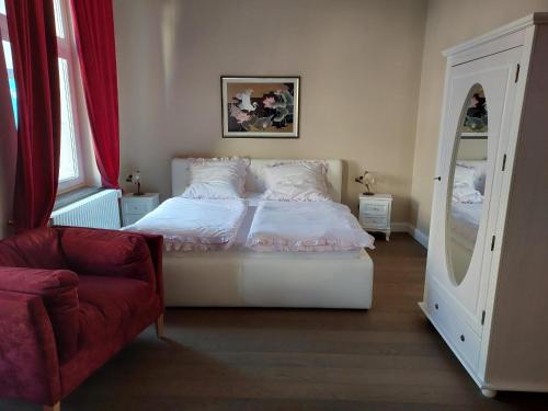 a bedroom with a bed and a chair and a mirror at Boutique-Hotel Villa Rosali in Hamburg
