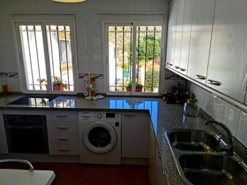 a kitchen with a sink and a washing machine at Blue jasmine in Cala del Moral